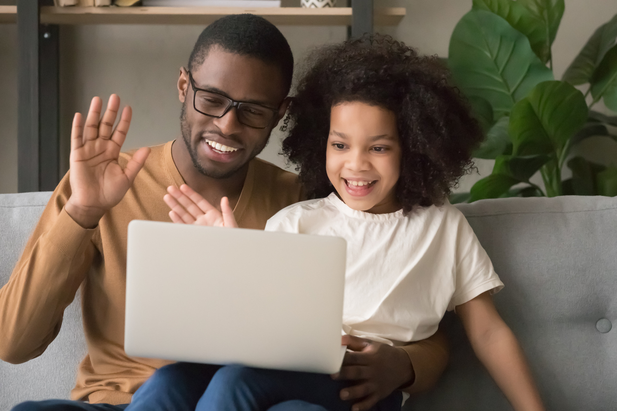 father child computer waving