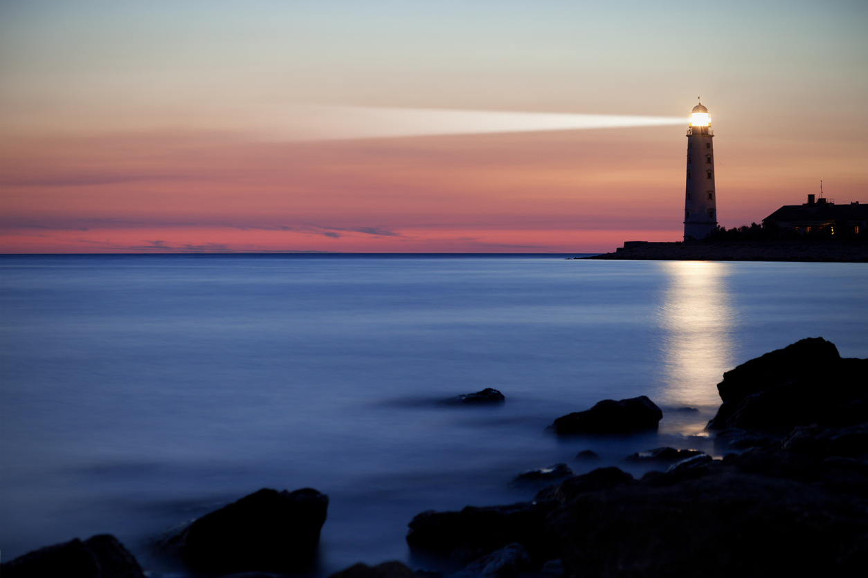 A lighthouse on the coast at sunset | Studer Education