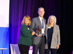 Mr. Rob Clayton accepting the 'Difference Maker Award' at the 2024 What's Right in Education alongside Dr. Janet Pilcher and Dr. Deanna Ashby.