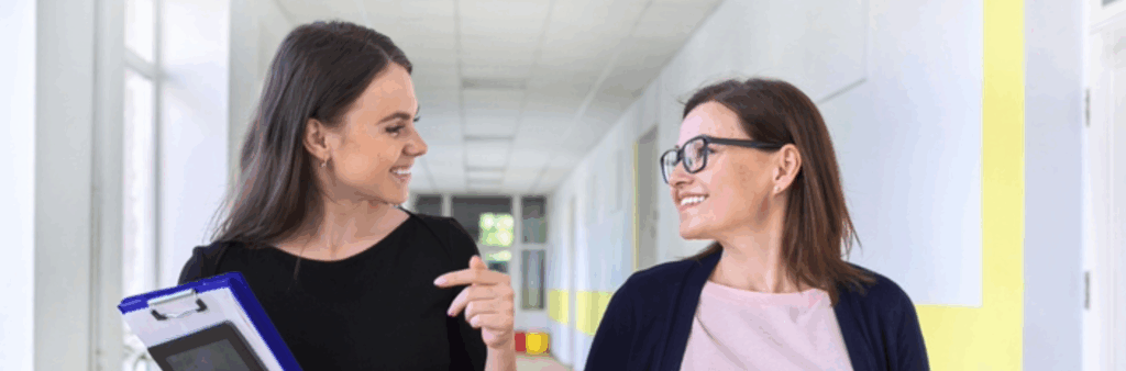 A female leader in school hallway working to develop a fellow leader.