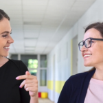A female leader in school hallway working to develop a fellow leader.