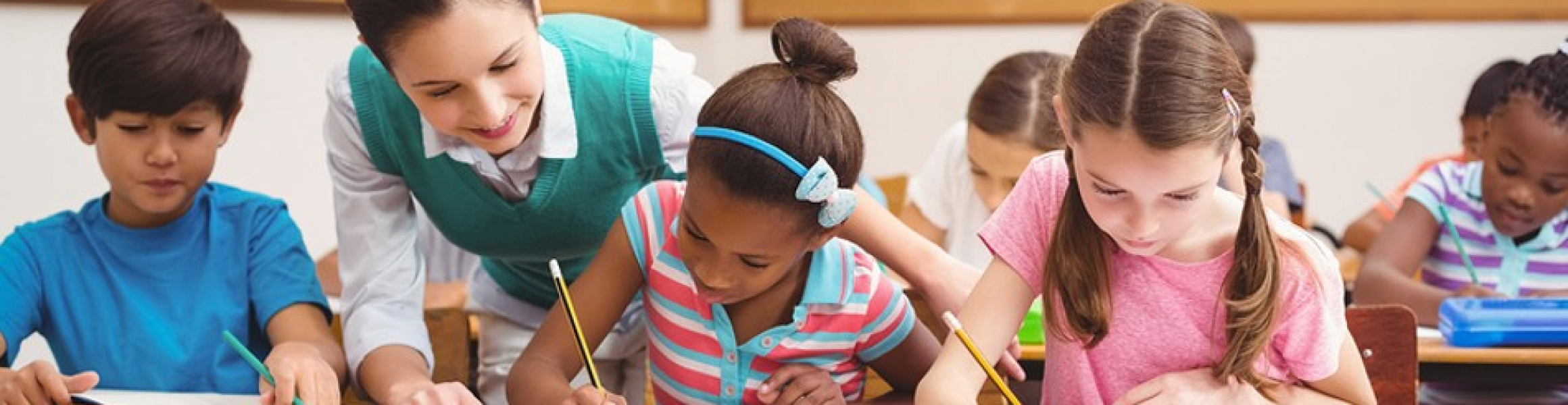 Teacher helping pupils during class at the elementary school | Studer ...